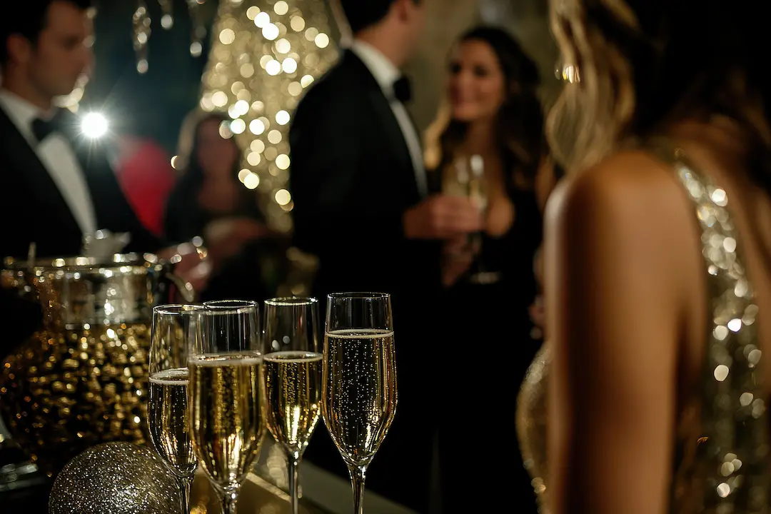 Glasses of sparkling wine in front of guests in evening wear